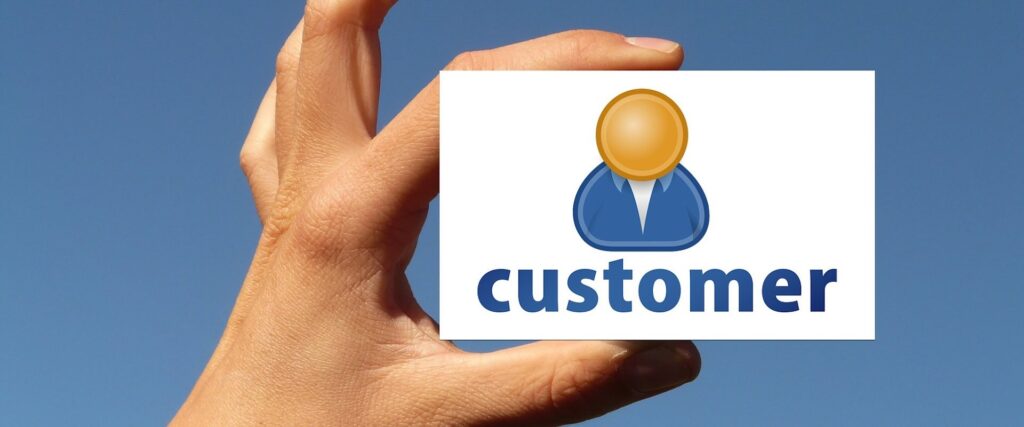 Hand holding card with word "customer" and icon representing person - WebGrit