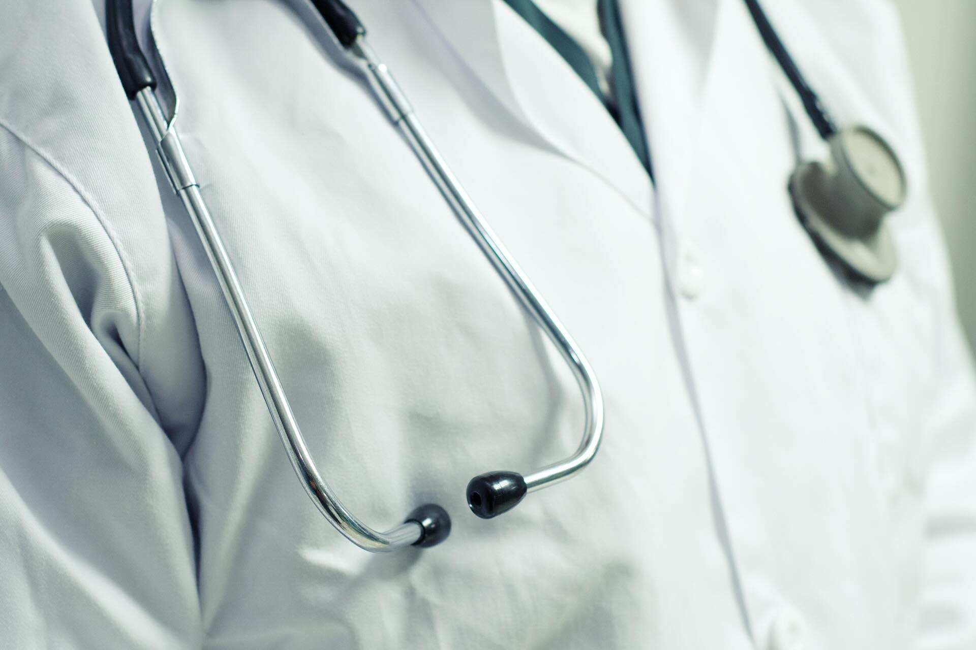 Chest of male doctor wearing stethoscope and white lab coat - WebGrit